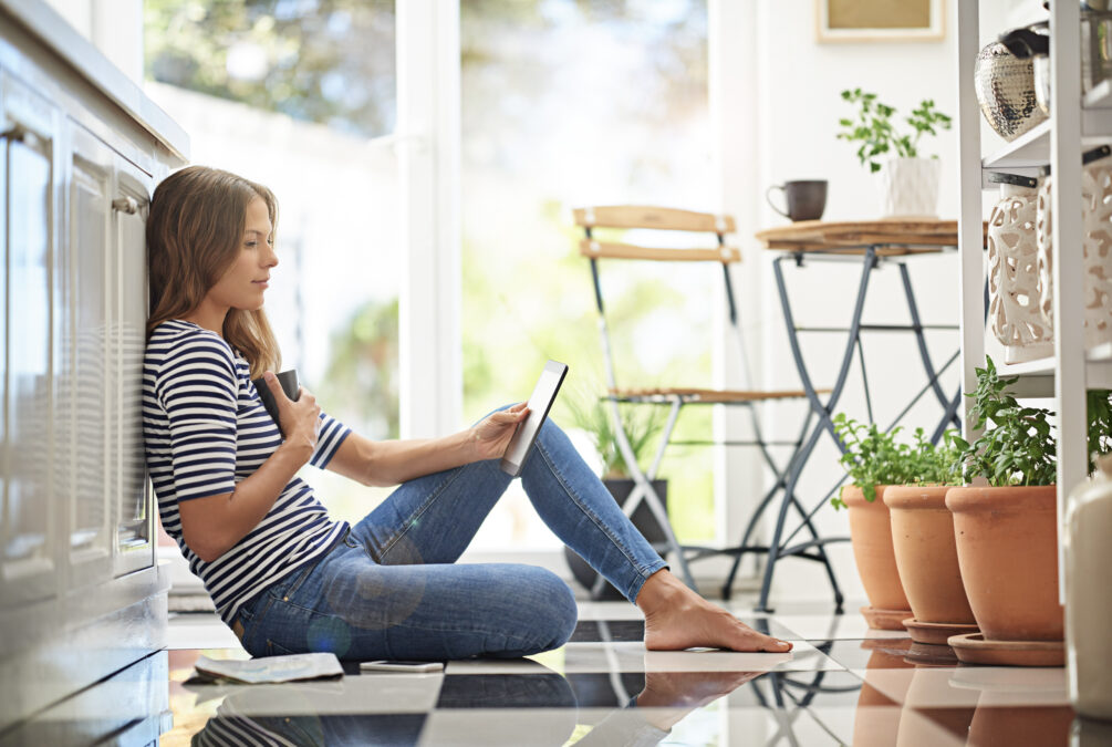 Femme assise par terre qui consulte une tablette