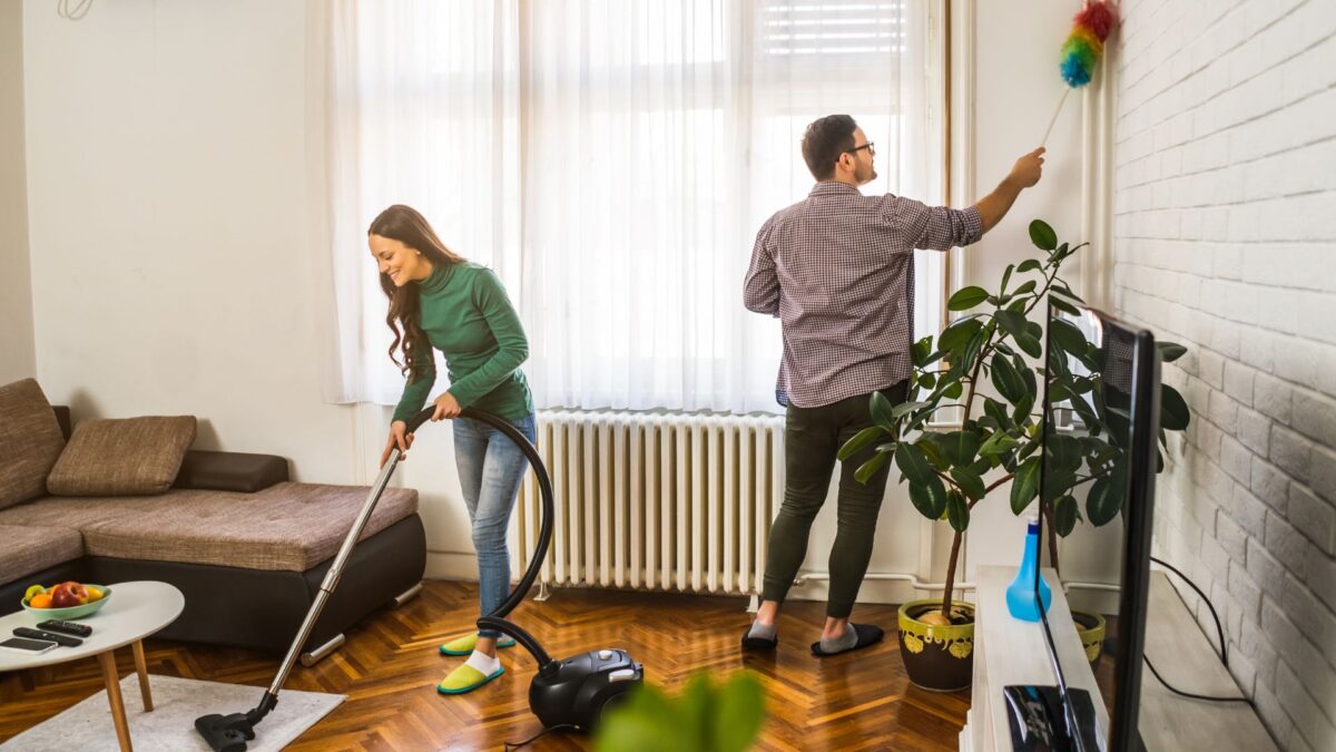 Un jeune couple nettoie le salon après son emménagement.