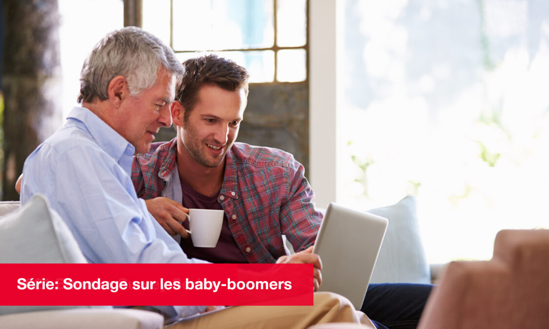 Père et fils regardant ensemble un ordinateur portable sur un canapé, planifiant l’avenir