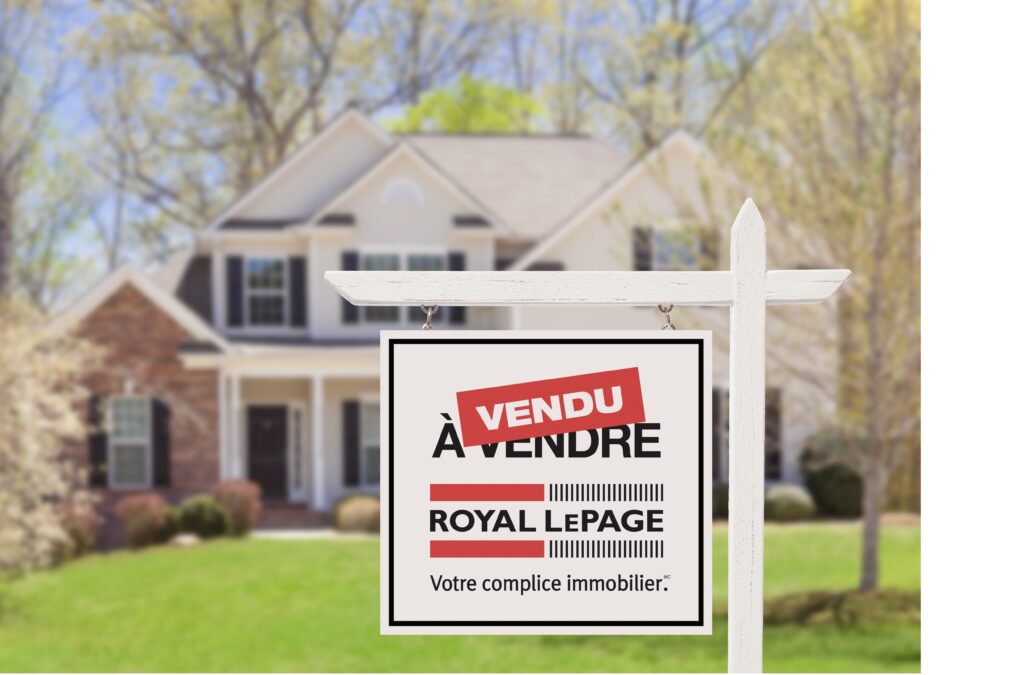 Enseigne de propriété vendue devant une maison par une journée ensoleillée