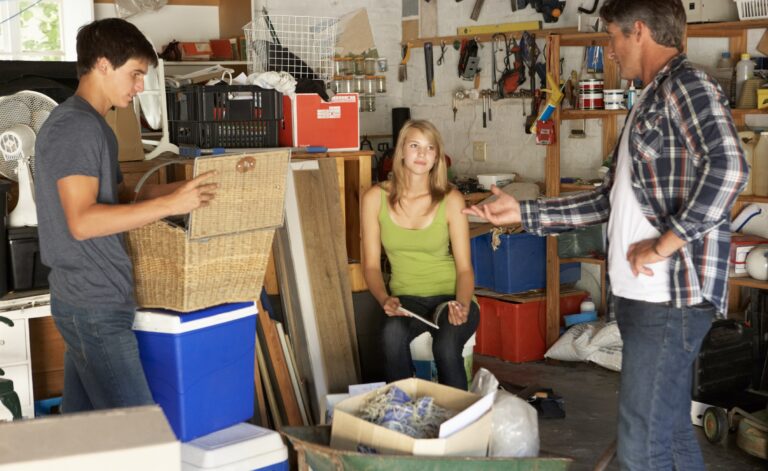 Un père et ses deux ados, garçon et fille, organisant des boîtes dans le garage