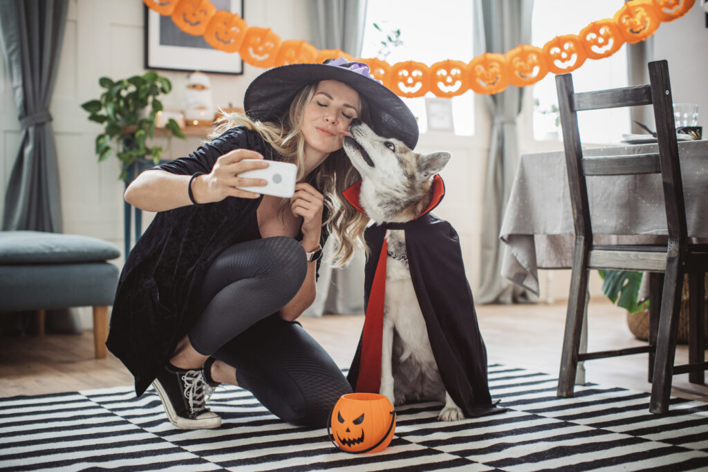 Une femme et un chien portant des costumes d’Halloween et en train de prendre un égoportrait