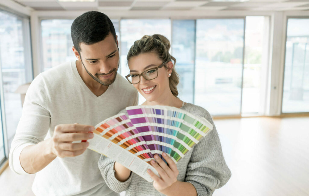 Un jeune couple qui examine une sélection d’échantillons de peinture