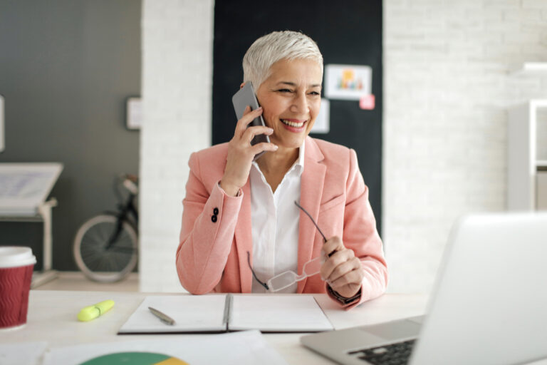 Une femme d’âge moyen parlant au téléphone dans son bureau