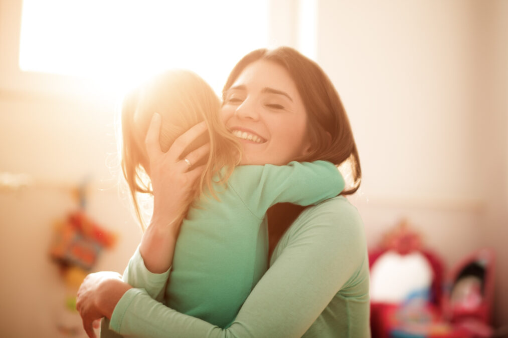Mère tient son jeune enfant, souriant