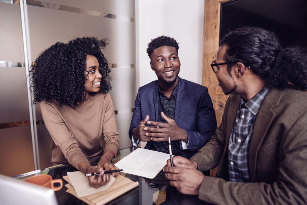 Jeune couple qui discute avec son courtier immobilier