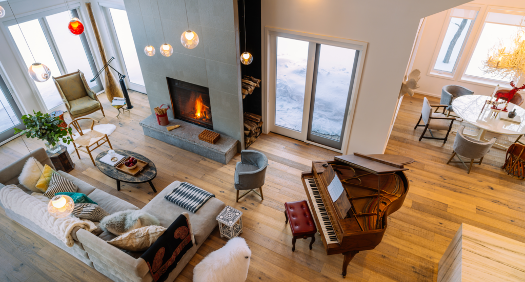 Vue aérienne d'un salon avec une cheminée allumée et un canapé en forme de L.