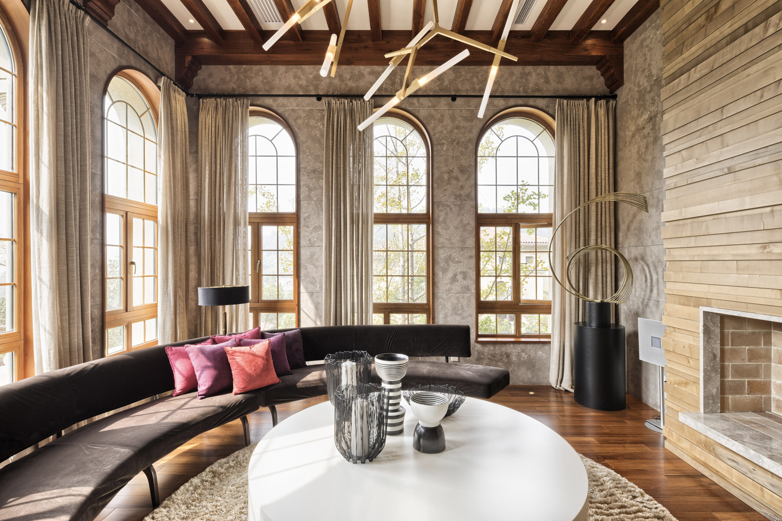 Un salon ensoleillé avec un canapé moderne aux formes arrondies autour d'une table circulaire.