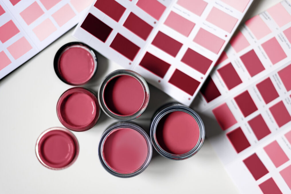 De petits pots de peinture ainsi que des échantillons des différentes teintes de magenta