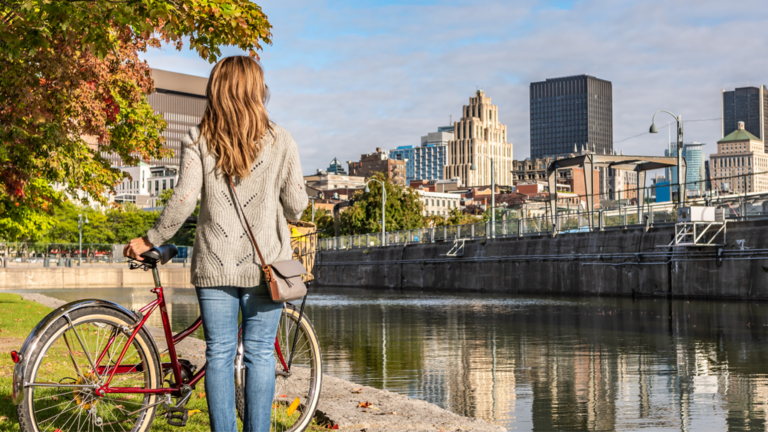 Femme portugaise faisant une promenade à vélo dans le Vieux-Port de Montréal et regardant le quartier du centre-ville lors d'un lever de soleil.