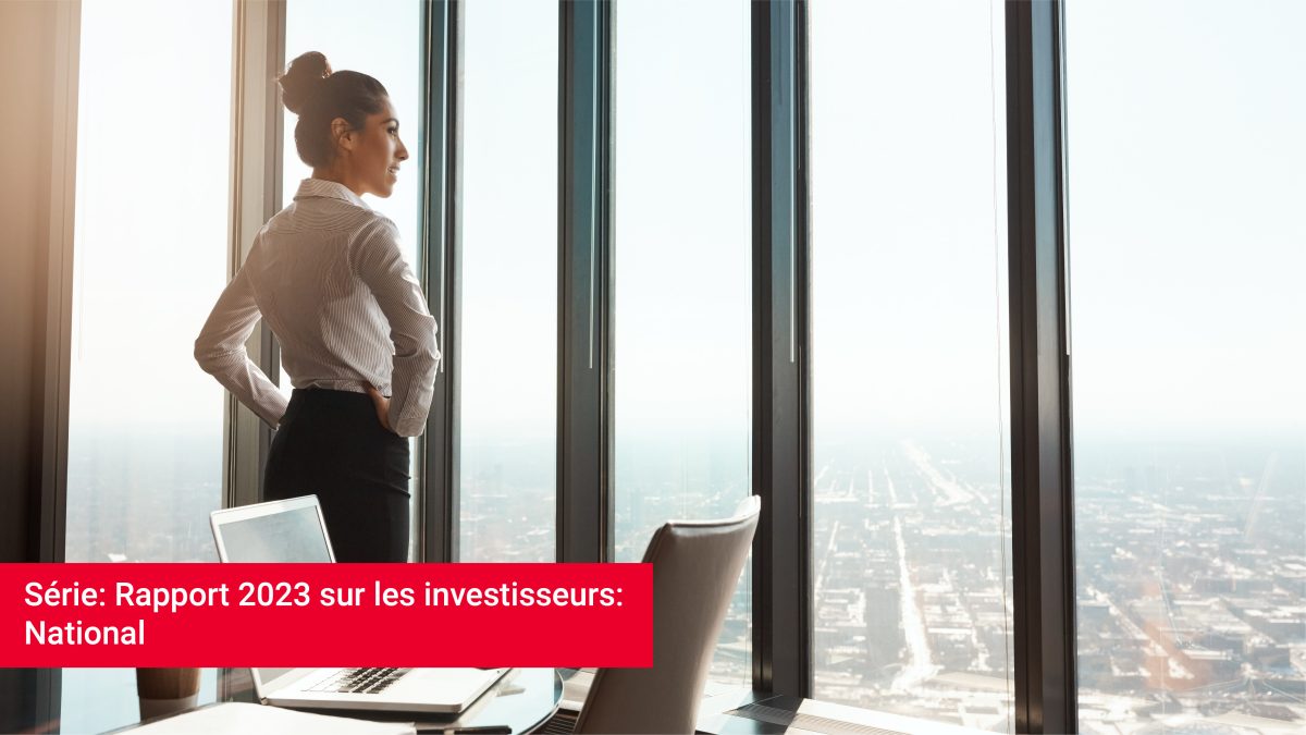 Une femme d'affaires regarde fièrement par la fenêtre qui donne sur la ville