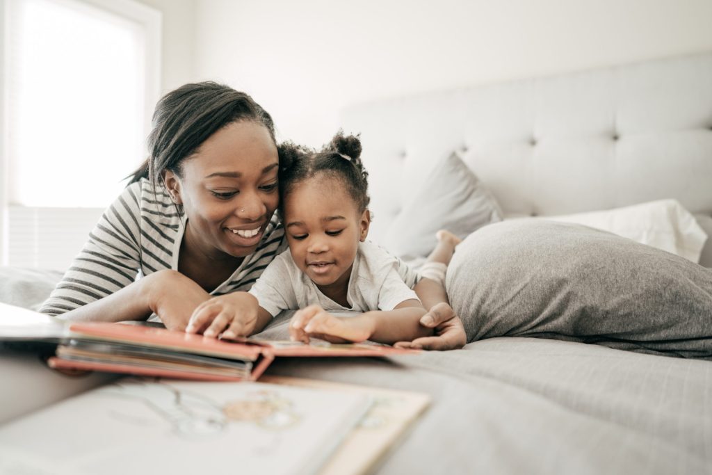 Une femme et son jeune enfant lisent ensemble sur un lit