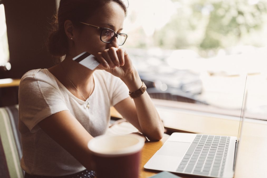 Femme dans un café avec son ordinateur portable ayant des problèmes avec sa carte de crédit