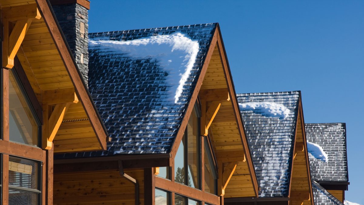 Toits enneigés des chalets de ski pendant la journée