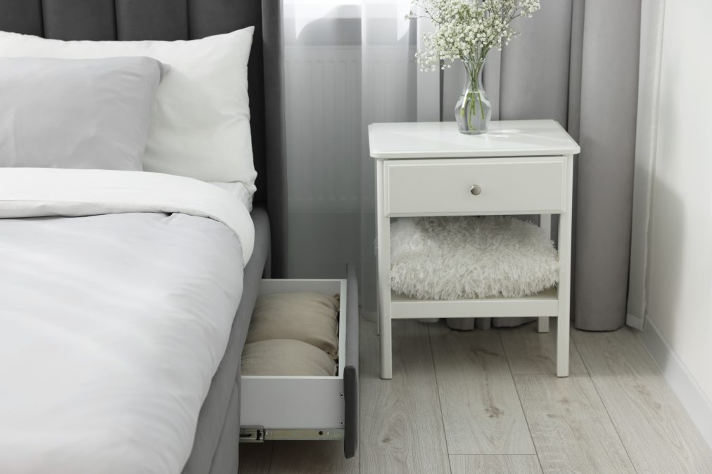 Tiroir de rangement contenant de la literie sous un lit confortable dans une chambre