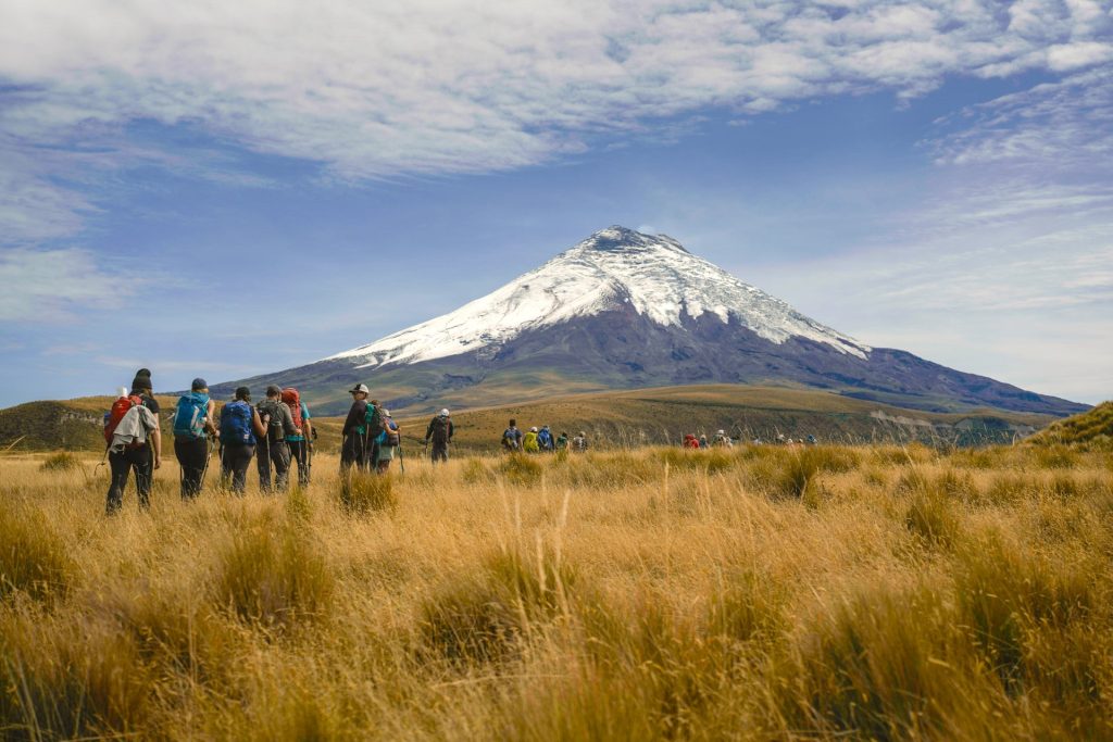 Randonneurs marchant dans un champ au pied d'une montagne équatorienne