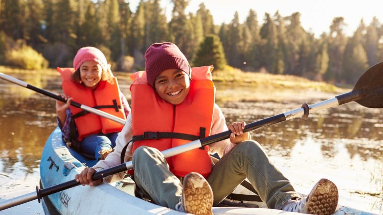 Deux enfants ramant en kayak sur un lac