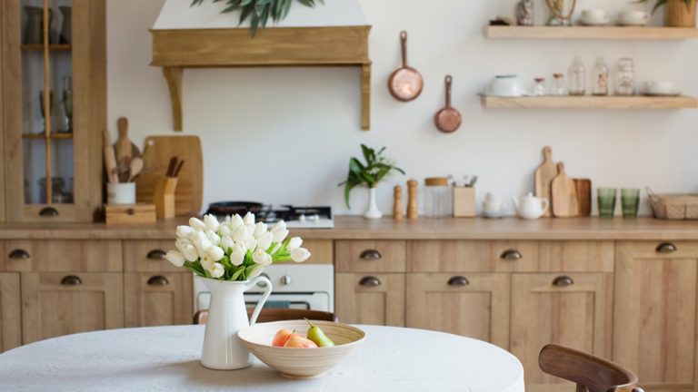 Un vase de tulipes blanches sur une table de cuisine ronde