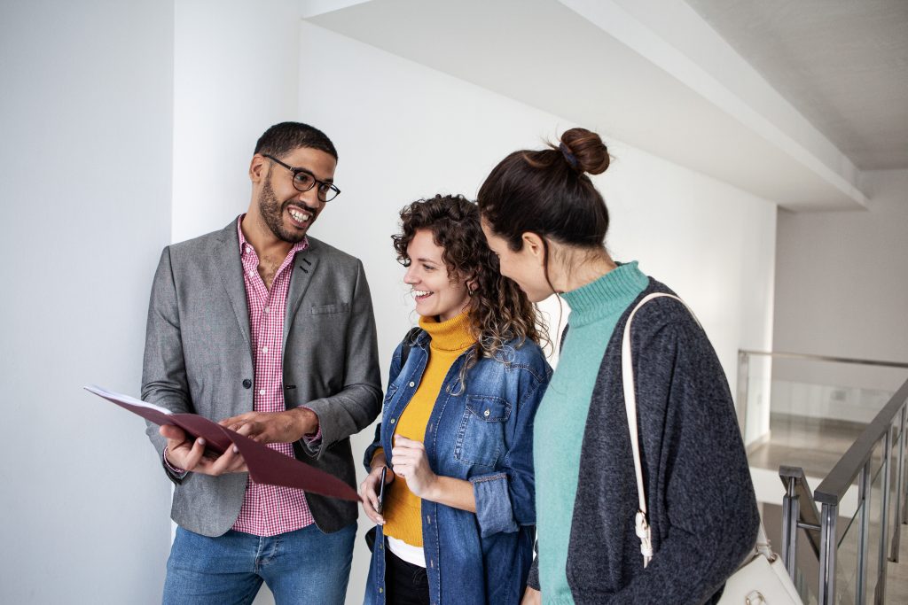 Femmes regardant un appartement vacant avec un agent immobilier