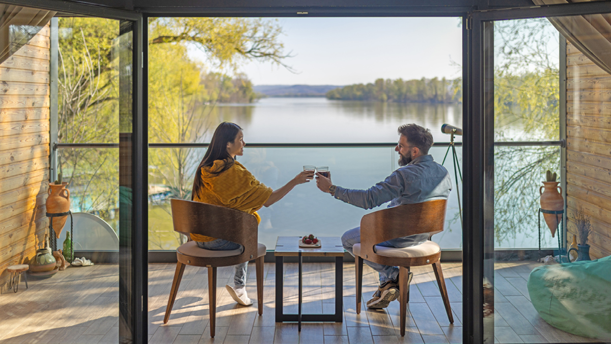 Couple assis sur une terrasse surplombant un lac pendant la journée