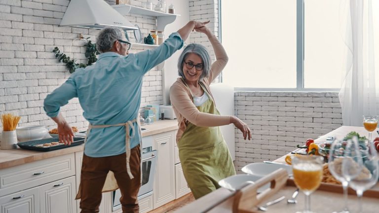 Un couple de retraités qui danse ensemble dans la cuisine