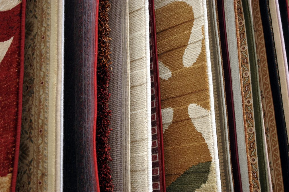 Area rugs and carpet samples hanging along the wall.