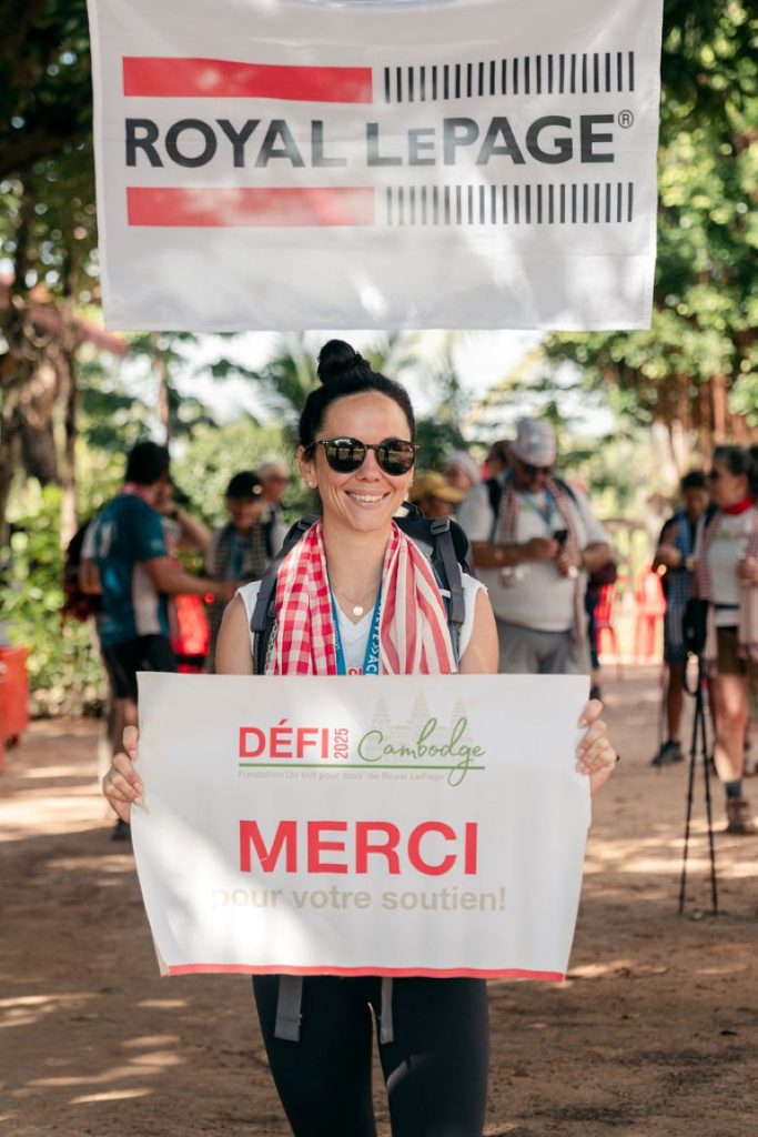 
Une randonneuse se tient debout avec un panneau « Merci ».