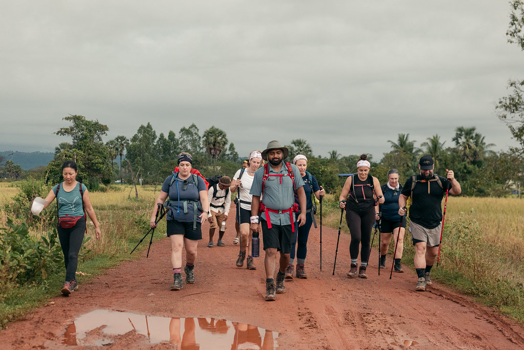 
Un groupe de randonneurs traverse un sentier boueux au Cambodge