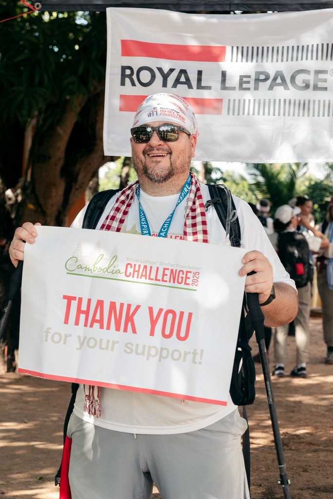 Un randonneur se tient debout avec une pancarte « Merci ».