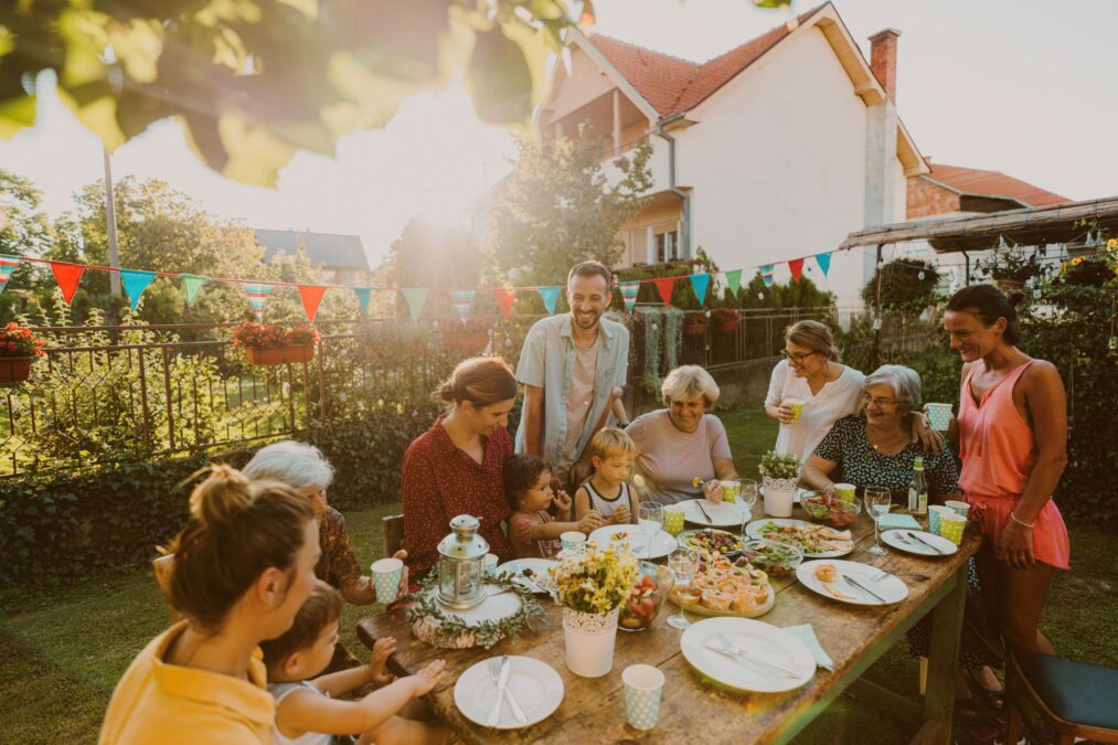 Photo of multi generation family, having summer party in the backyard.