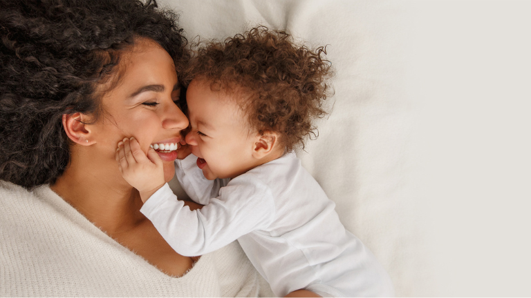 Une mère et son jeune enfant blottis l'un contre l'autre sur le lit
