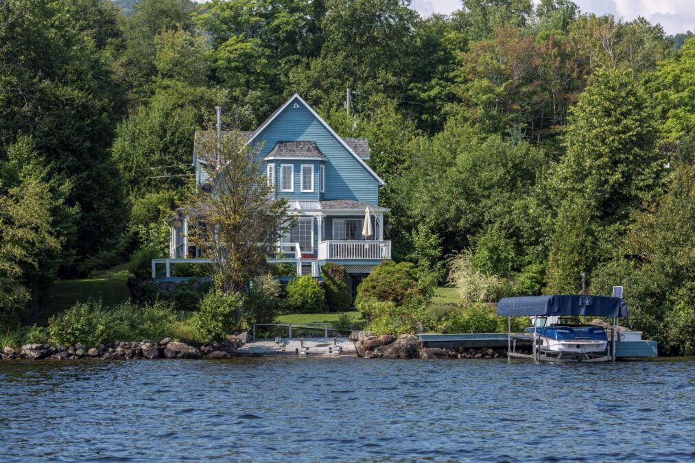 Un chalet bleu au bord de l'eau avec vue sur le lac