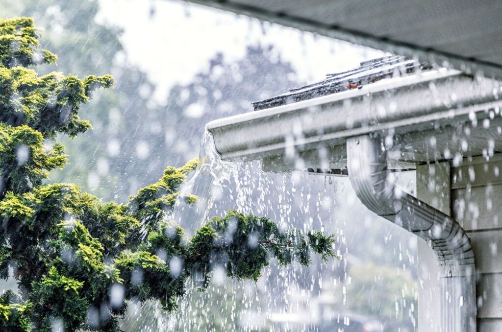 Des gouttières débordant d'eau de pluie sur une propriété résidentielle